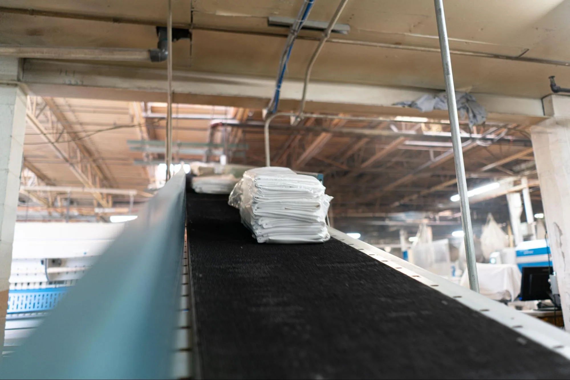 City Valley Linen commercial laundry conveyor belt with freshly cleaned linens