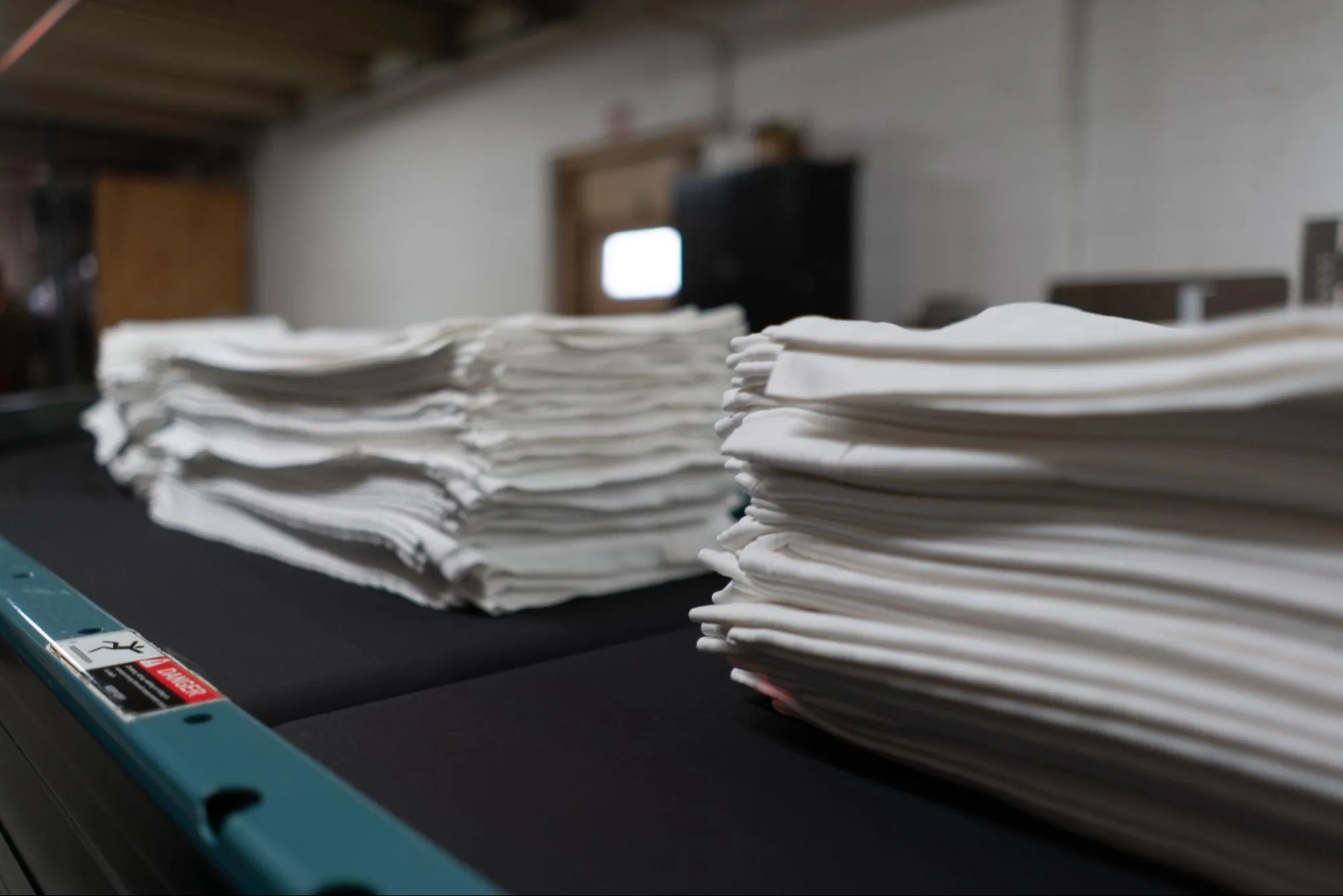 Industrial linen processing on conveyor belt at City Valley Linen facility